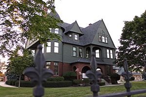 A Victorian mansion in Manitowoc behind an iron fence